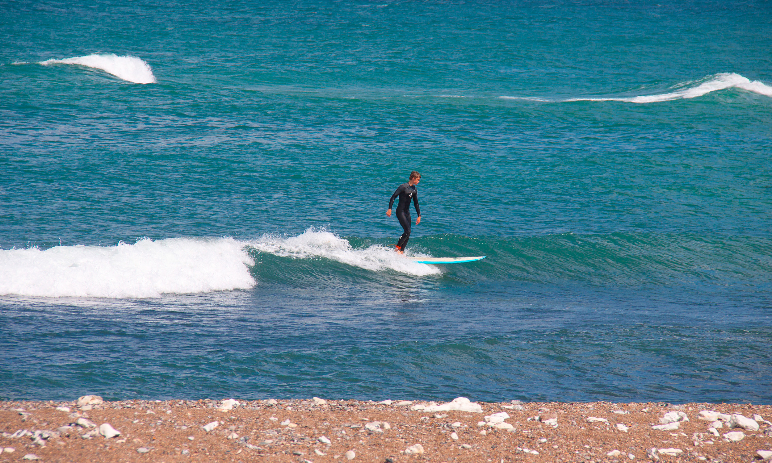 Surfers riding waves in Klitmøller, illustrating the vibrant